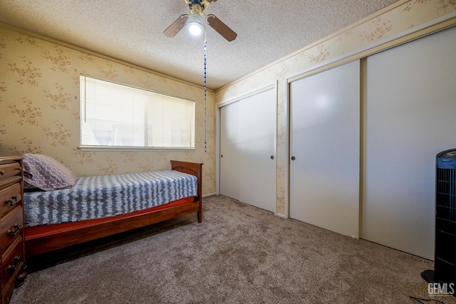 4508 Glengary Pl, Bakersfield, CA 93313 - bedroom featuring carpet flooring, two closets, a textured ceiling, a ceiling fan, and wallpapered walls