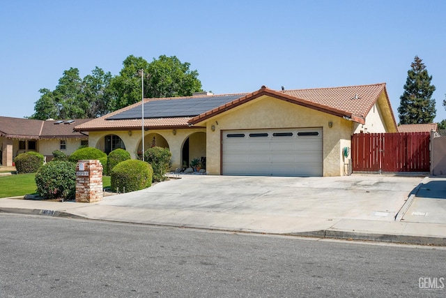 4508 Glengary Pl, Bakersfield, CA 93313 - mediterranean / spanish-style home with a tiled roof, solar panels, a garage, and stucco siding
