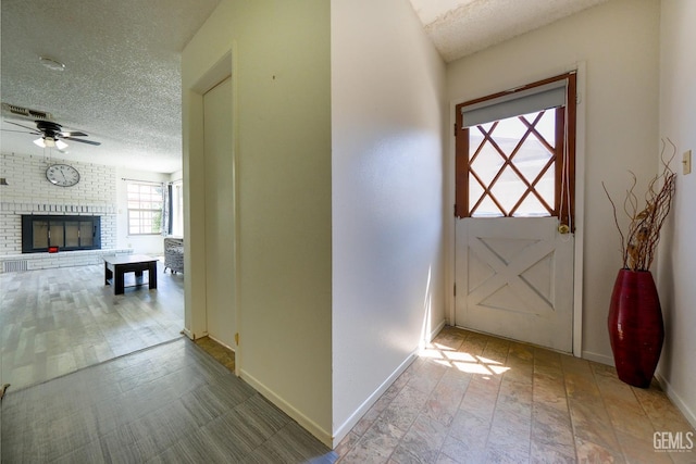 4508 Glengary Pl, Bakersfield, CA 93313 - entryway with a textured ceiling, baseboards, a ceiling fan, and a brick fireplace