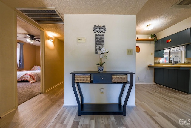 4508 Glengary Pl, Bakersfield, CA 93313 - hallway featuring light wood finished floors, a textured ceiling, and baseboards
