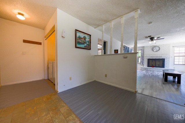 4508 Glengary Pl, Bakersfield, CA 93313 - unfurnished living room with a textured ceiling, a ceiling fan, a brick fireplace, baseboards, and washer / clothes dryer