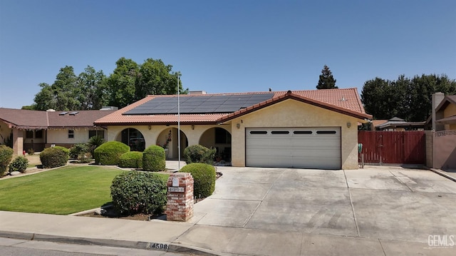 4508 Glengary Pl, Bakersfield, CA 93313 - mediterranean / spanish-style house featuring a garage, roof mounted solar panels, concrete driveway, a tiled roof, and stucco siding