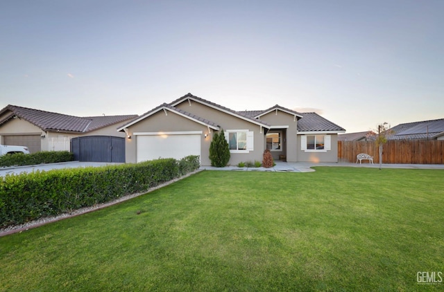 ranch-style house featuring an attached garage, a gate, fence, a front lawn, and stucco siding