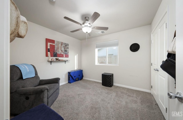 living area featuring ceiling fan, carpet flooring, visible vents, and baseboards