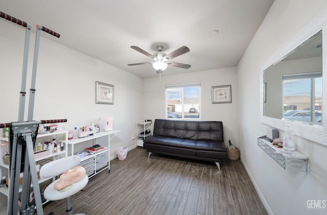 living area with ceiling fan, wood finished floors, and baseboards