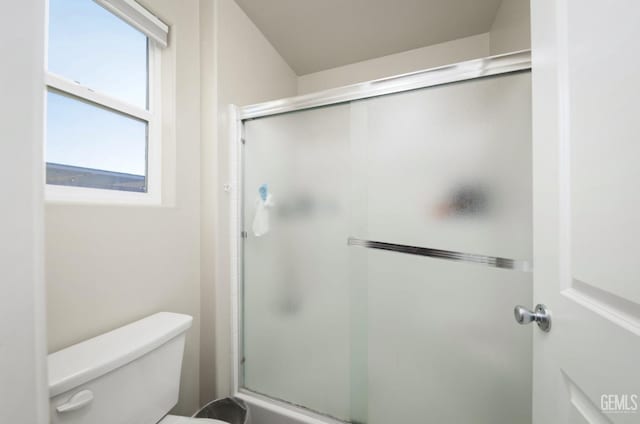 bathroom with a shower stall and toilet