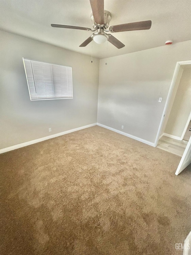 spare room featuring baseboards, carpet, and ceiling fan