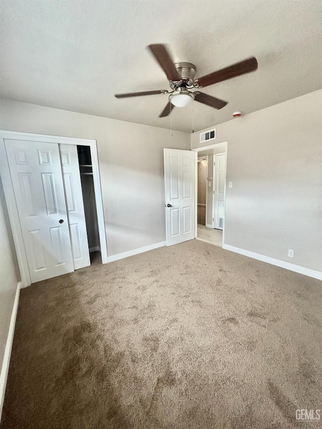 unfurnished bedroom featuring visible vents, baseboards, carpet, a textured ceiling, and a ceiling fan