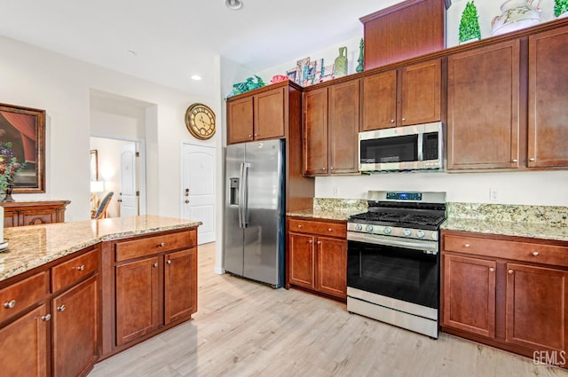13500 Sunlight Star St, Bakersfield, CA 93314 - kitchen with stainless steel appliances, light wood-type flooring, light stone counters, recessed lighting, and brown cabinets