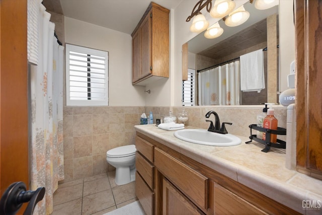 bathroom featuring tile patterned flooring, vanity, toilet, and tile walls