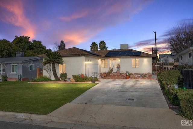 view of front of house with solar panels and a lawn