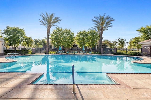 community pool featuring a patio and fence
