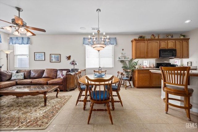dining room with light tile patterned flooring, visible vents, and ceiling fan with notable chandelier