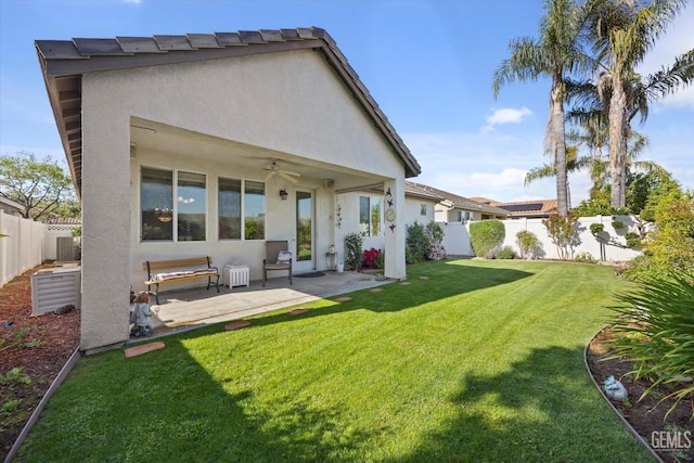 back of property with ceiling fan, stucco siding, and a fenced backyard