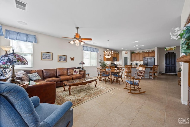 living room with recessed lighting, light tile patterned flooring, visible vents, baseboards, and ceiling fan with notable chandelier