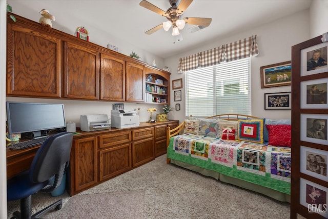 office with built in desk, a ceiling fan, and light carpet