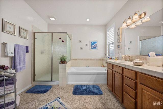 bathroom with a stall shower, a bath, and vanity