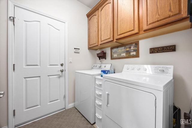 clothes washing area featuring cabinet space, washing machine and clothes dryer, and light carpet