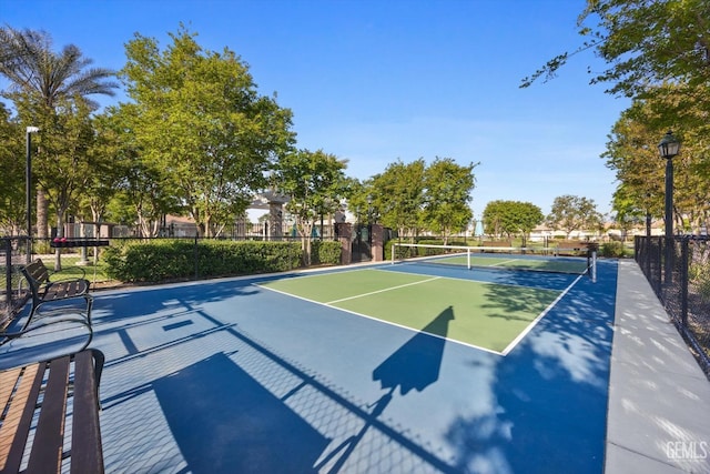 view of sport court featuring a tennis court, fence, and community basketball court