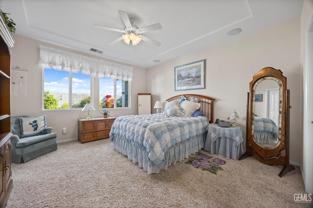 bedroom featuring a ceiling fan, visible vents, light carpet, and baseboards