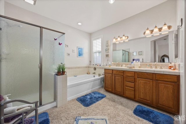 full bathroom featuring double vanity, a shower stall, a bath, and a sink