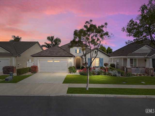 view of front of property with stucco siding, a tiled roof, a garage, a front lawn, and concrete driveway