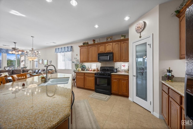 kitchen with light stone counters, brown cabinets, a sink, black appliances, and recessed lighting