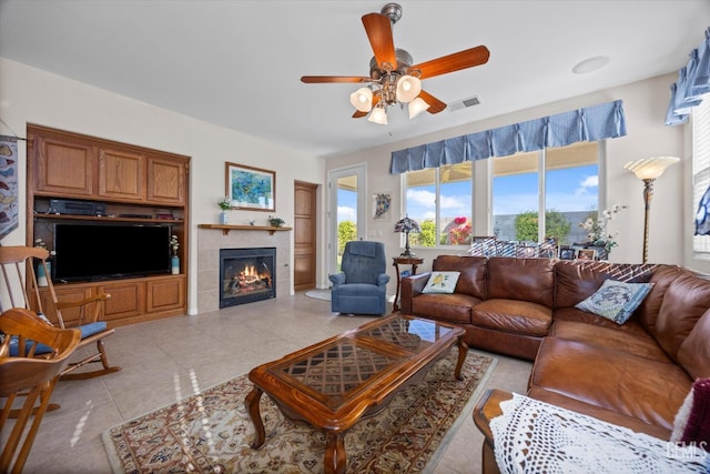 living area with visible vents, light tile patterned floors, a ceiling fan, and a fireplace