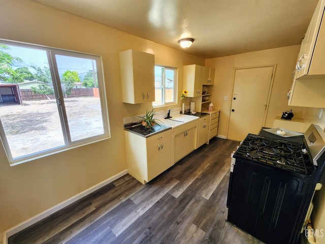 4856 Morales St, New Cuyama, CA 93254 - kitchen featuring stainless steel range with gas stovetop, dark wood-type flooring, baseboards, white cabinetry, and a sink