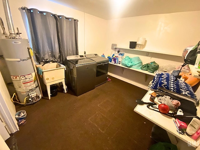 clothes washing area with dark carpet, gas water heater, sink, and washing machine and clothes dryer