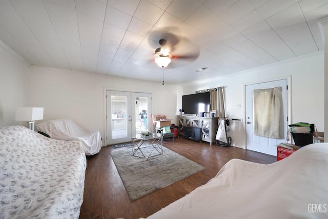 living room featuring crown molding, ceiling fan, french doors, and dark wood-type flooring