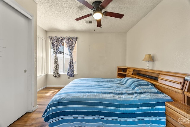 1914 Hummingbird Ave, Delano, CA 93215 - bedroom with a textured ceiling, wood finished floors, ceiling fan, and baseboards