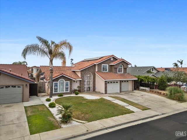 1914 Hummingbird Ave, Delano, CA 93215 - view of front of house featuring a tiled roof, driveway, solar panels, stucco siding, and a garage