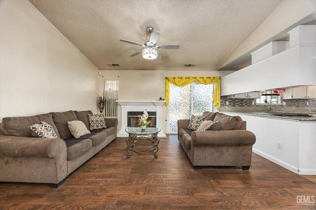 1914 Hummingbird Ave, Delano, CA 93215 - living area with vaulted ceiling, a textured ceiling, ceiling fan, dark wood finished floors, and a glass covered fireplace