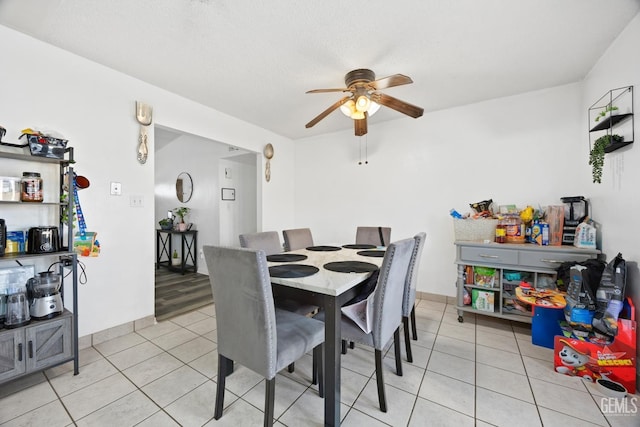 dining area featuring light tile patterned floors, a textured ceiling, and ceiling fan