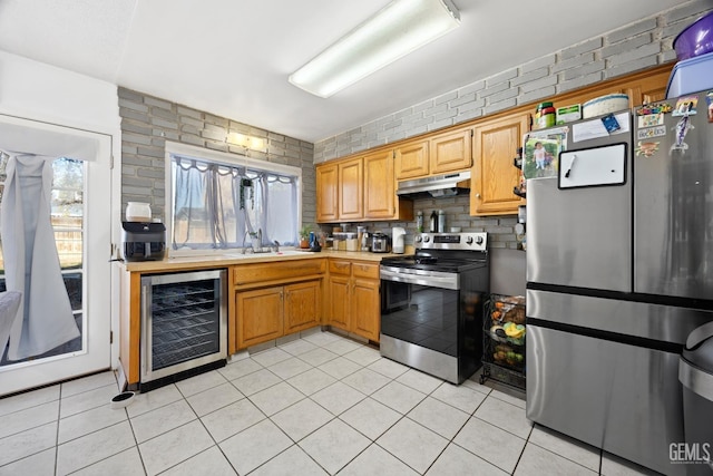 kitchen with wine cooler, stainless steel appliances, light tile patterned flooring, and plenty of natural light