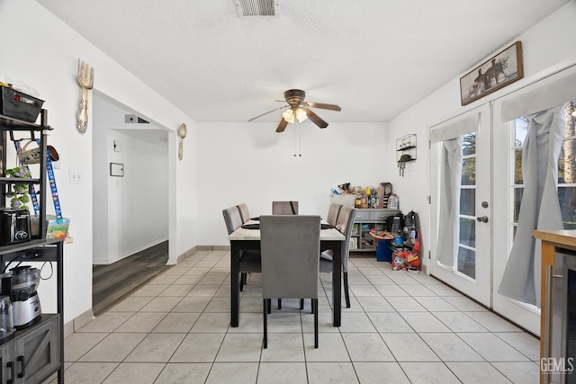 tiled dining area featuring ceiling fan, wine cooler, a textured ceiling, and french doors