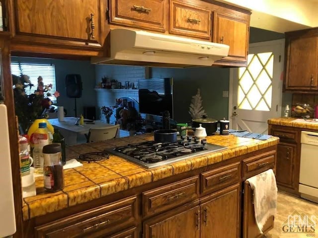 kitchen featuring white dishwasher, tile counters, stainless steel gas cooktop, and tasteful backsplash