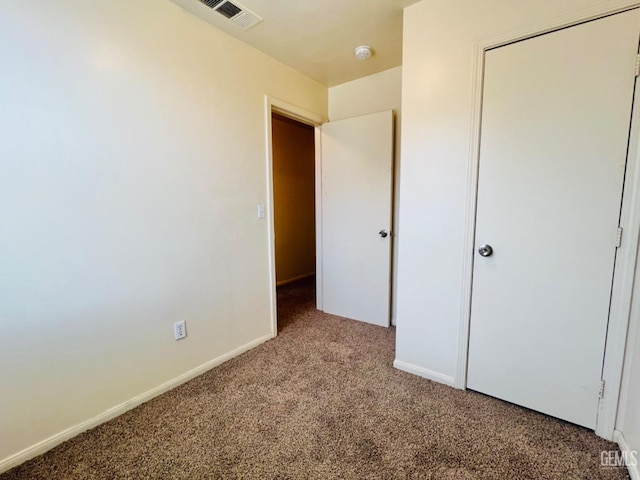 unfurnished bedroom featuring light colored carpet and a closet