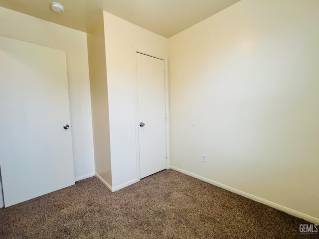 unfurnished bedroom featuring carpet floors and a closet