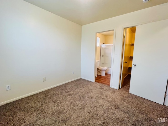 unfurnished bedroom with a walk in closet, carpet floors, ensuite bath, and a closet