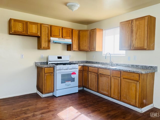 kitchen featuring white range with gas cooktop, sink, and dark wood-type flooring