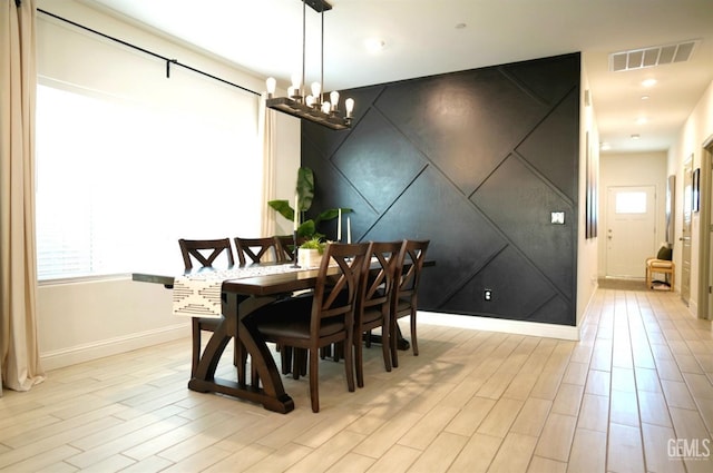 dining space featuring light wood-type flooring and a chandelier