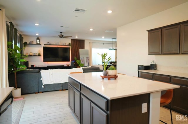 kitchen featuring dark brown cabinets, ceiling fan, and a kitchen island