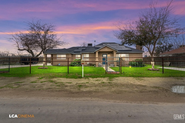 view of front of home featuring a lawn and solar panels