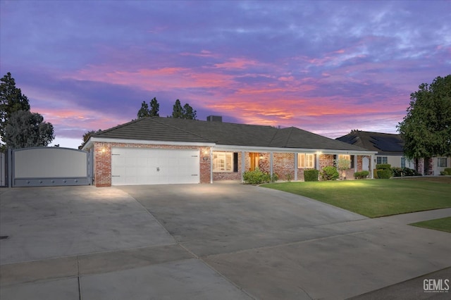 ranch-style house with a garage and a yard