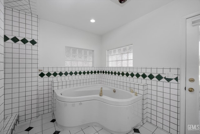 bathroom featuring tile patterned flooring, tile walls, and a bathing tub