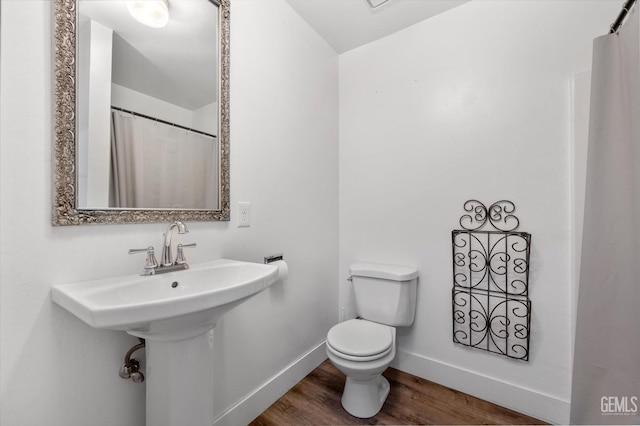 bathroom with hardwood / wood-style floors and toilet