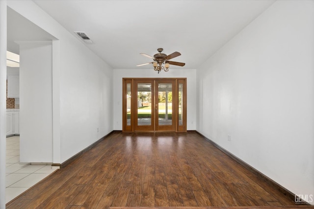 spare room featuring hardwood / wood-style flooring, ceiling fan, and french doors