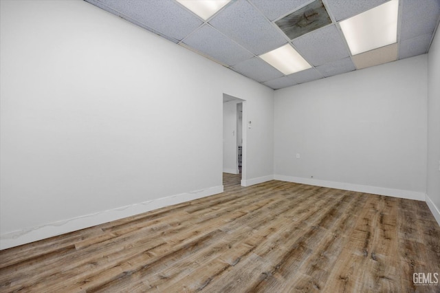 unfurnished room featuring a paneled ceiling and hardwood / wood-style floors